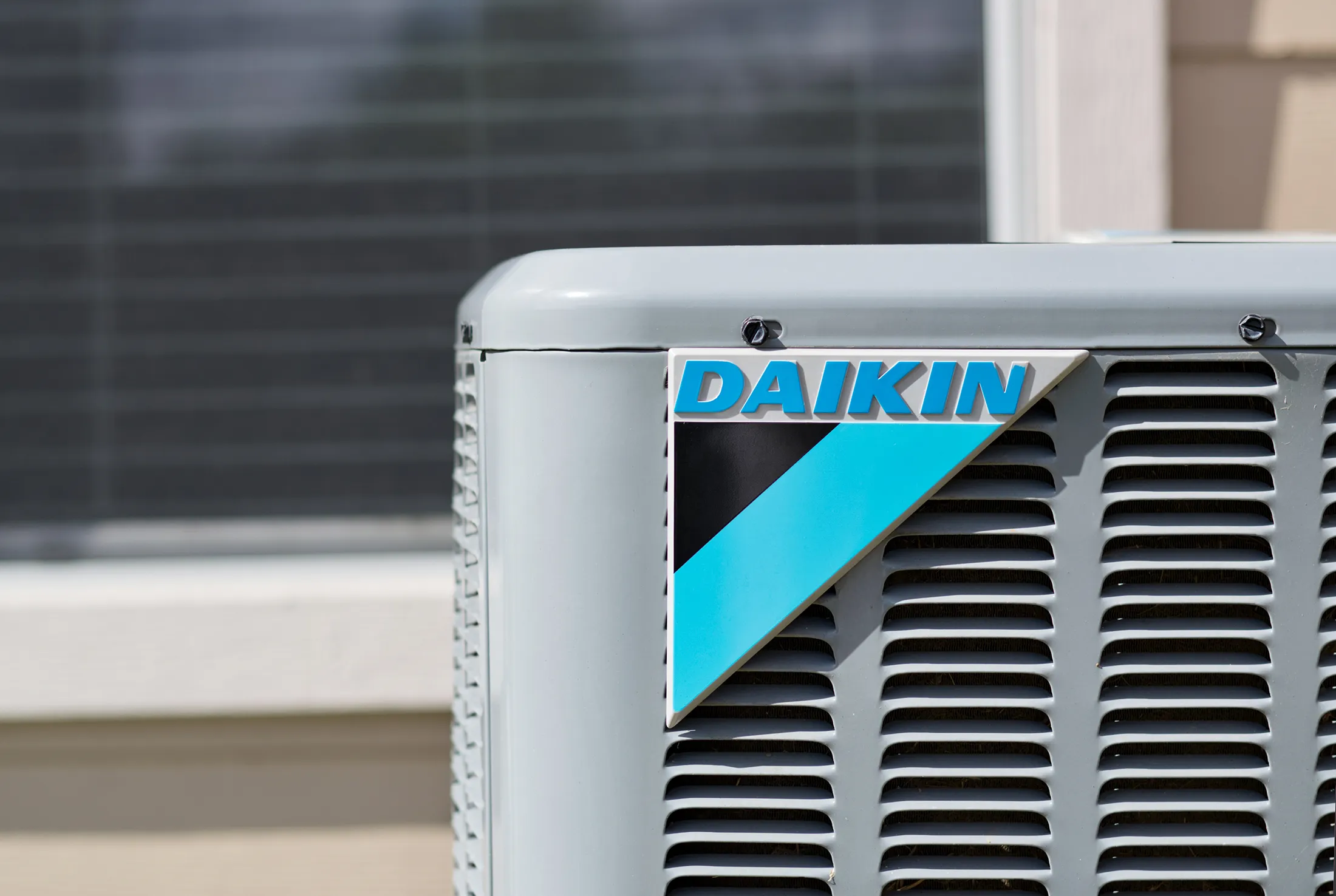 Daikin HVAC unit close up compressor outside with window in the background