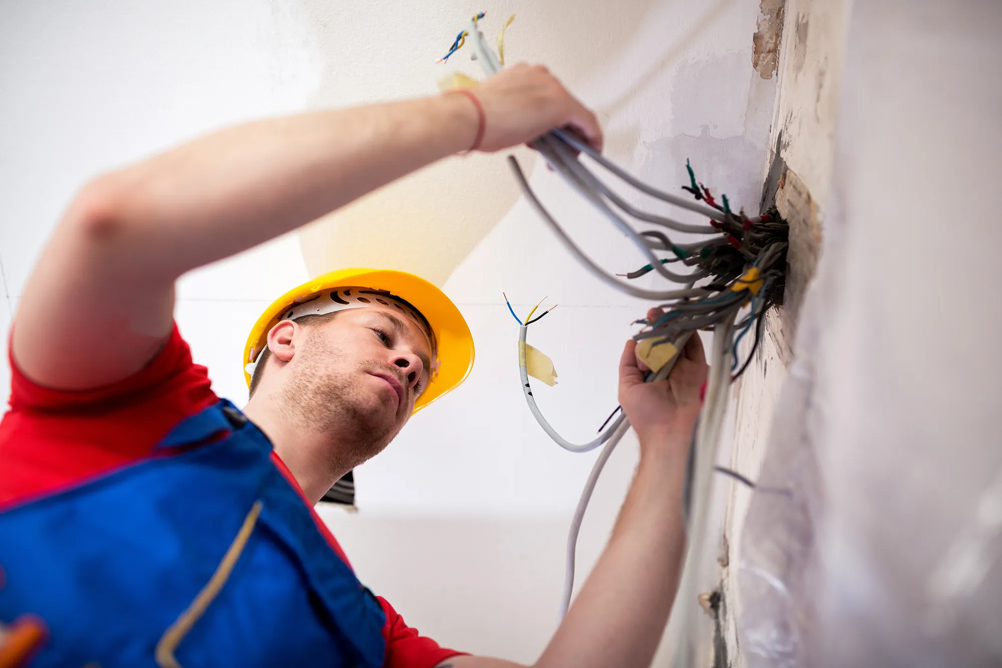 electrician pulling wires from wall