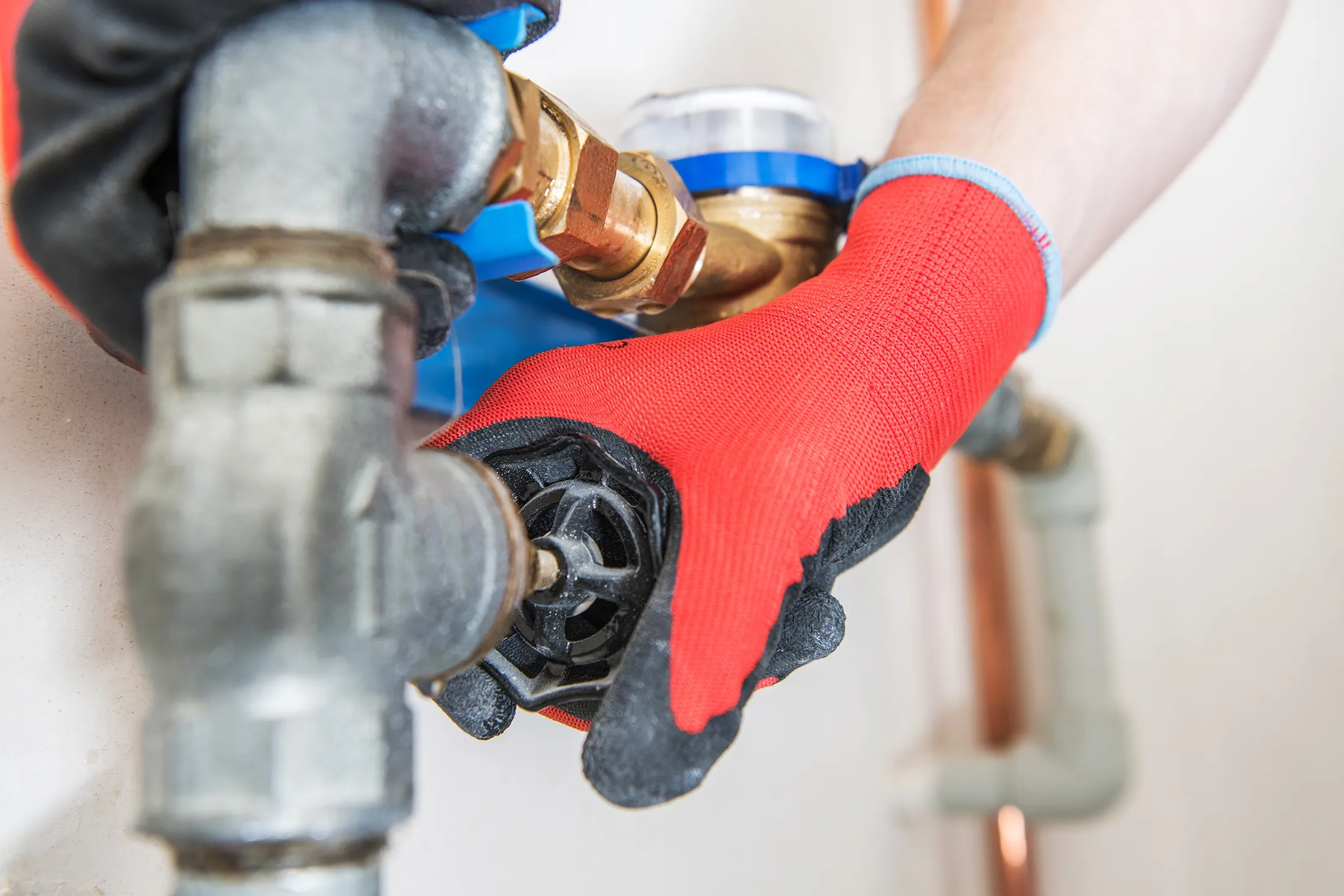 hand on pipe wearing a red glove