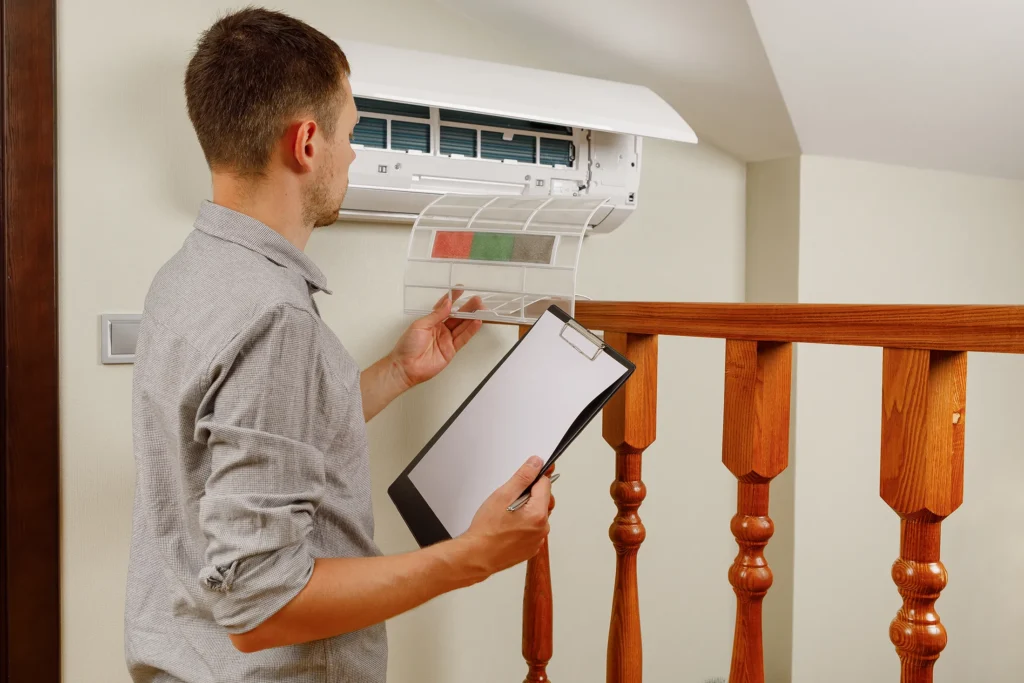 Man looking at an HVAC unit on the wall