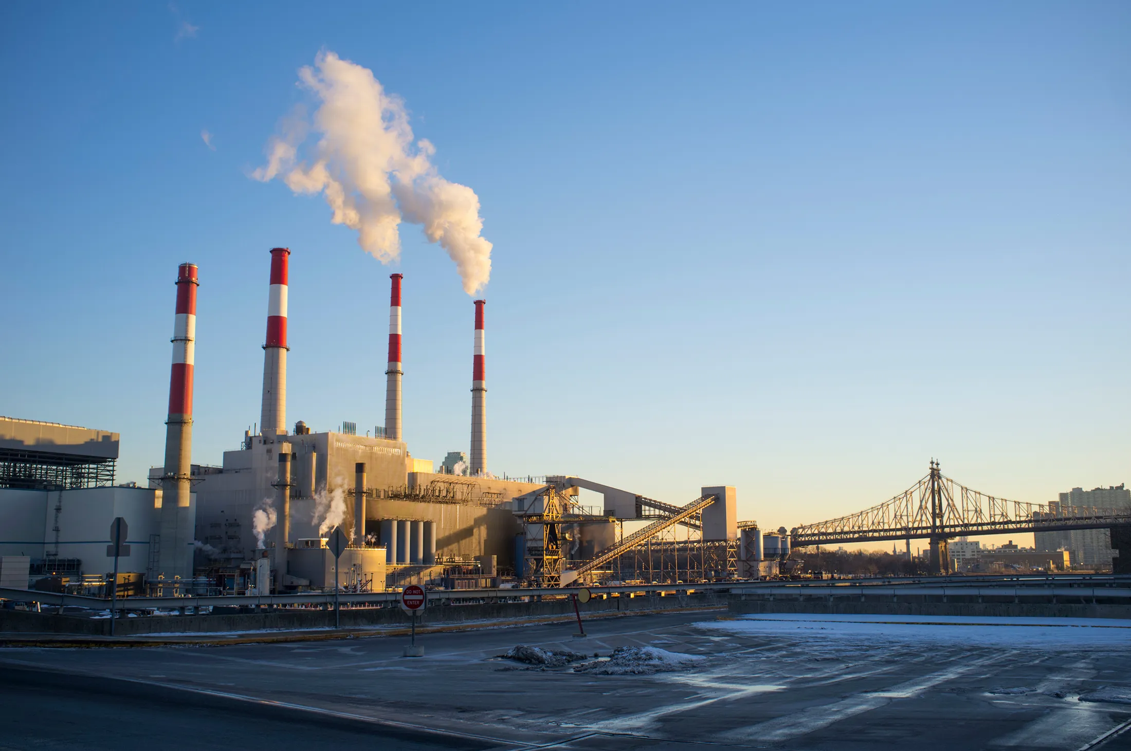 Image of a factory with smoke coming out of its stacks